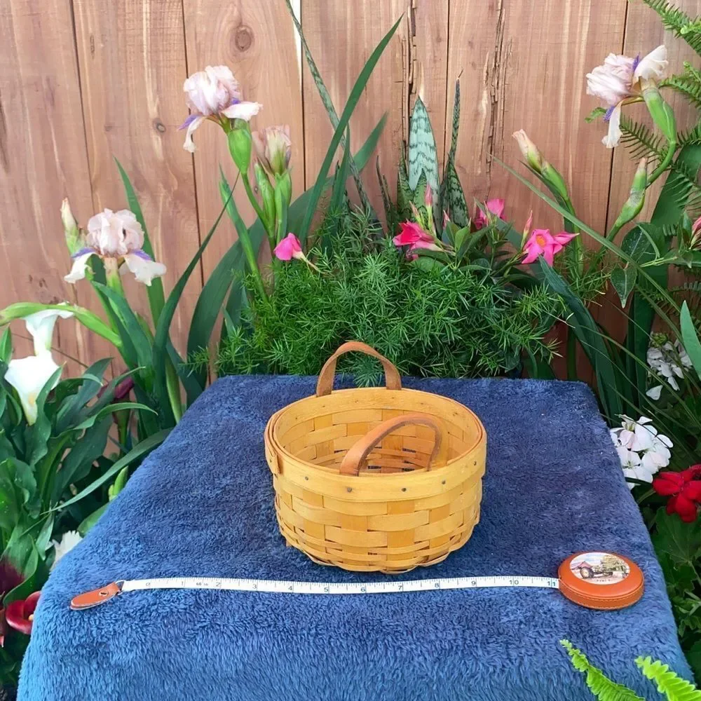 Circular basket with plastic insert and leather handles by Longaberger